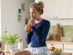 Woman with a thorax garment drinking a smoothie