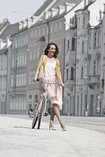 Una mujer que lleva Juzo Inspiration y pasea por las calles con la bicicleta