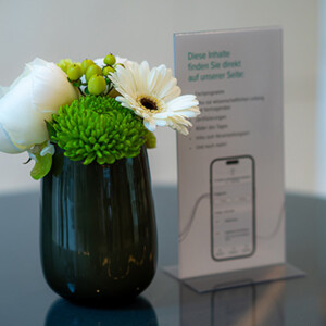 Blumenvase und Flyer vom Berliner Lymphologischen Symposium