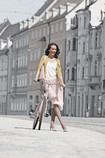 Una mujer que lleva Juzo Inspiration y pasea por las calles con la bicicleta