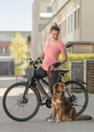 Frau auf einem Fahrrad mit Hund