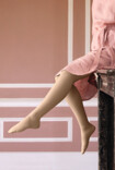 Woman wears the Juzo Soft and sits on the mantelpiece