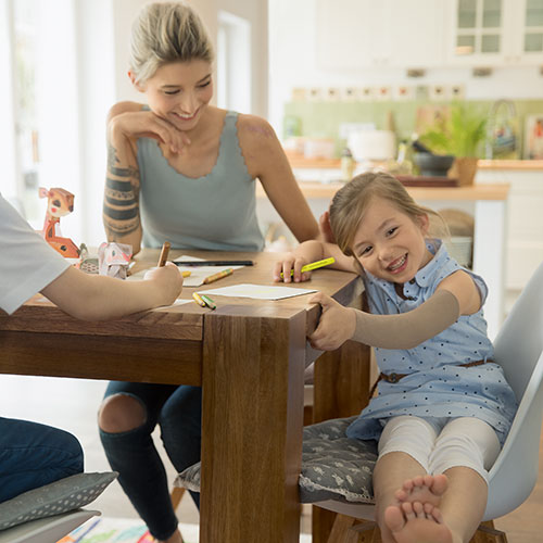 Mutter und Kind sitzen zusammen am Esstisch und haben Spaß