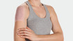 Frau trägt ein Juzo Scarpad auf ihrer Narbe auf dem Oberarm