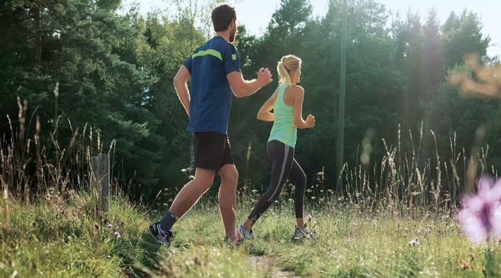 Dolores en el tobillo Un hombre y una mujer practicando jogging