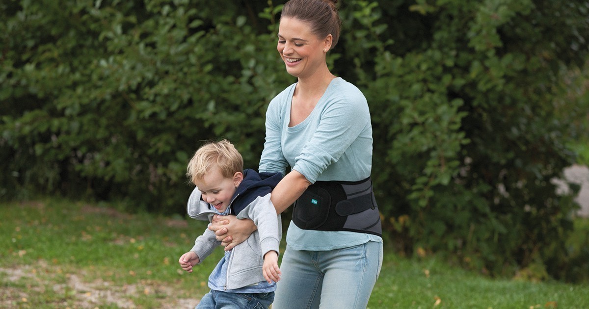 Frau mit JuzoPro Lumbal trägt Kind