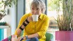 Woman wearing the JuzoPro Manu Xtec Palmar wrist orthosis holds a cup in her hand