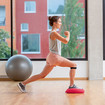 A woman doing a lunge forwards on a soft cushion