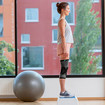 Frau steht mit beiden Beinen auf Step-Aerobic-Brett