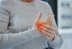 Eine Frau hält sich ihre schmerzenden Finger