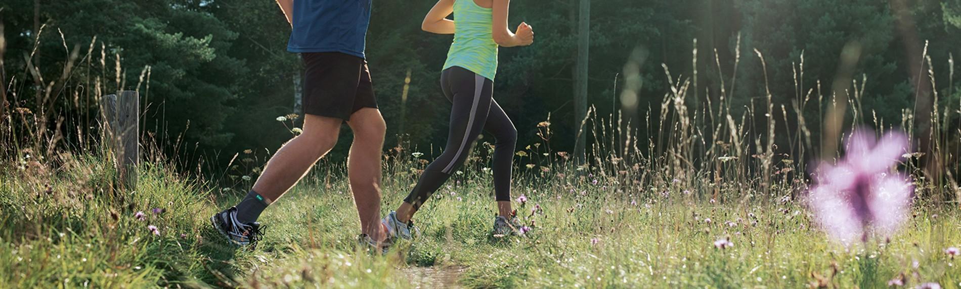 Fotled Kvinna och man som joggar i skogen