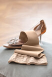 Juzo Soft stocking lies on a cushion next to a Cinderella shoe