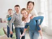 Photo d'une famille dans le salon où la femme porte un bandage thoracique bleu