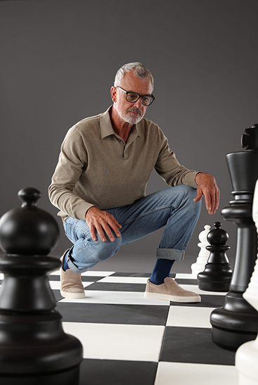 2. Lifestyle Image Juzo Dynamic Man wears Juzo Dynamic and kneels on a large chessboard