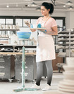 Une femme examine des plats en céramique et porte des bas de compression Juzo Inspiration dans la couleur Dip Dye marine