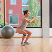 A woman doing squats with arms in front of her chest